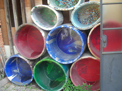 These are color pots that are stacked here and there at the Smalti factory.  These pots are in the furnace filled with molten glass.  The color you see in the pots is the residual color from previous runs of glass